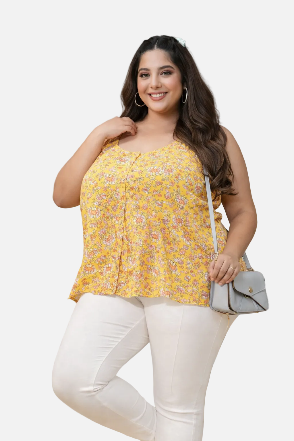 Woman wearing a yellow floral top and white pants in an indoor setting.