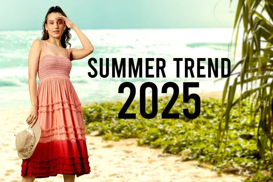 Woman in a sleeveless pink ombre dress holding a hat on a sunny beach, summer 2025 fashion trend