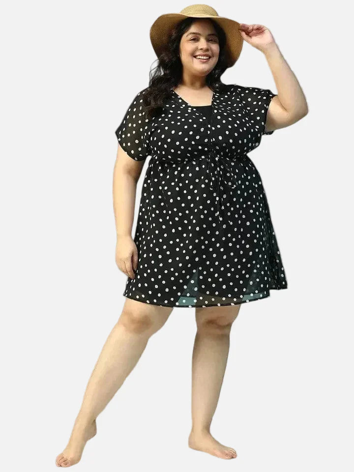 Plus size woman in black polka dot dress with drawstring waist and straw hat