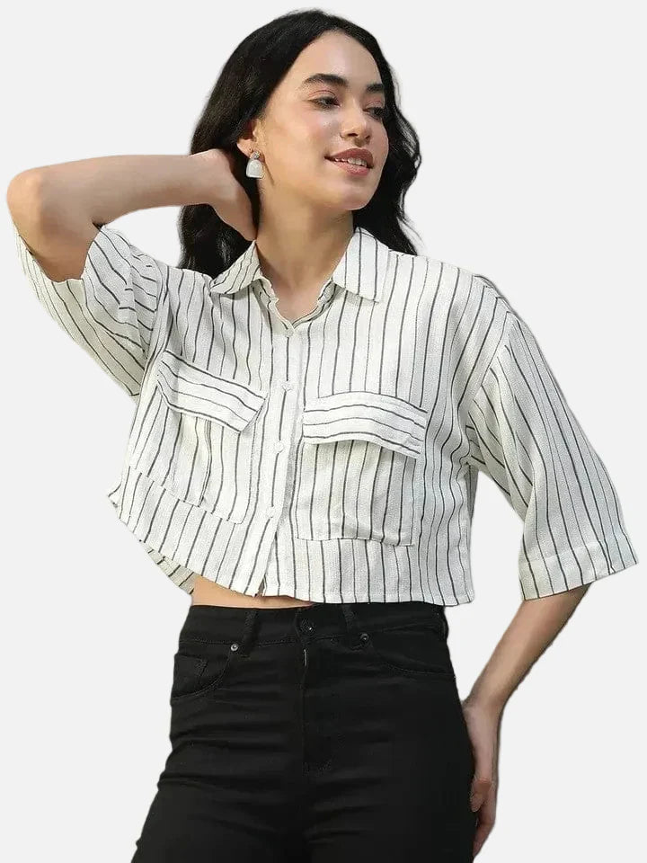 Woman wearing black jeans and a white striped button-up crop shirt with front pockets