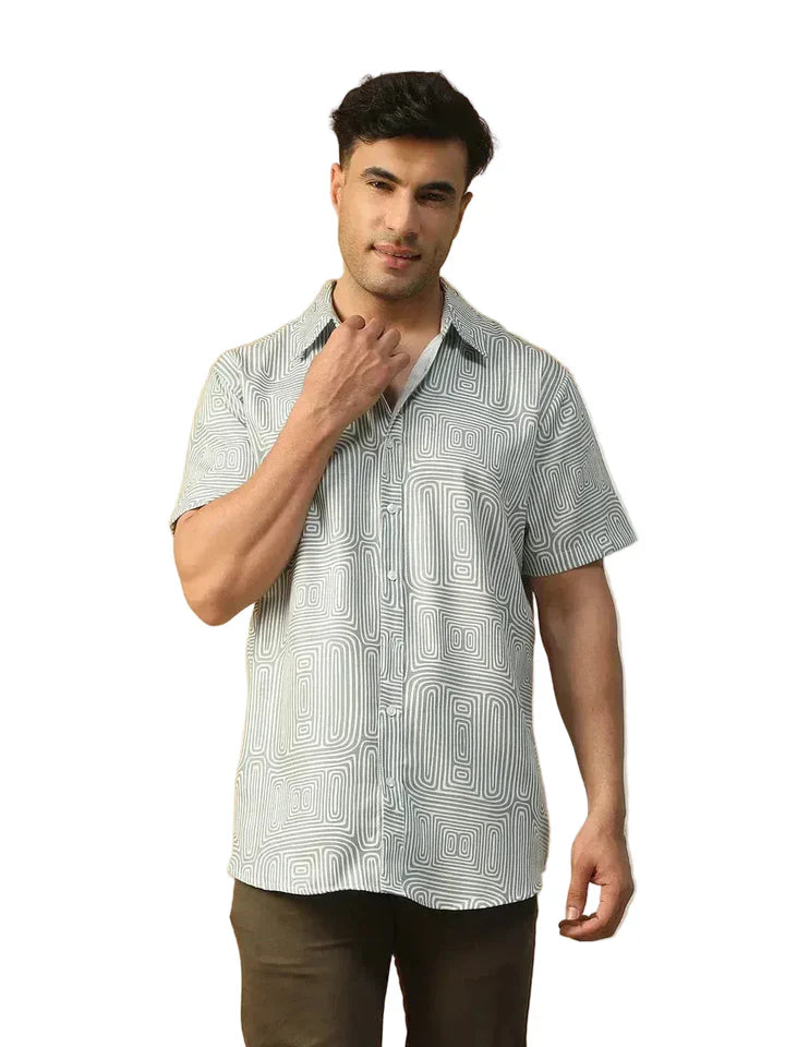 Man wearing short sleeve geometric print button-up shirt and dark pants