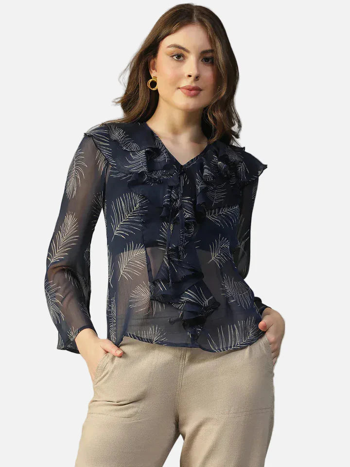 Woman wearing sheer navy blue leaf print ruffle blouse with long sleeves