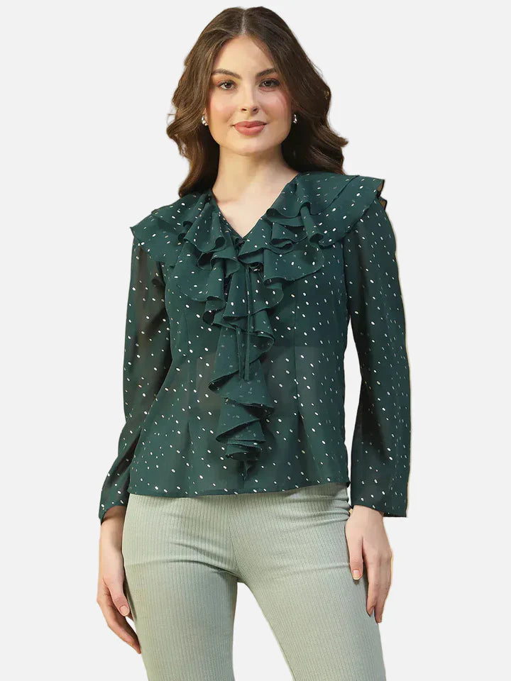 Woman wearing a green polka dot ruffle front blouse with long sleeves and v-neck