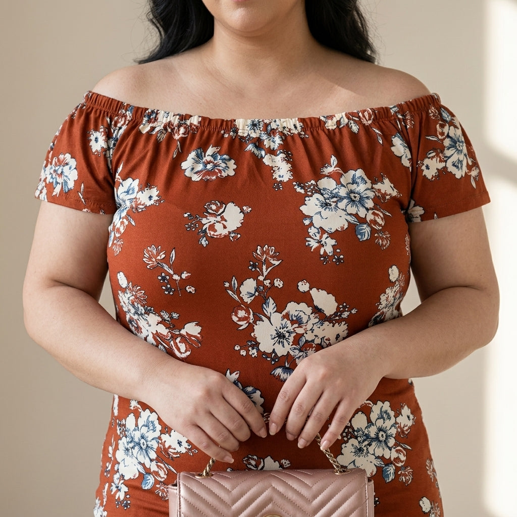 Plus size woman in an off-shoulder floral dress holding a quilted pink handbag