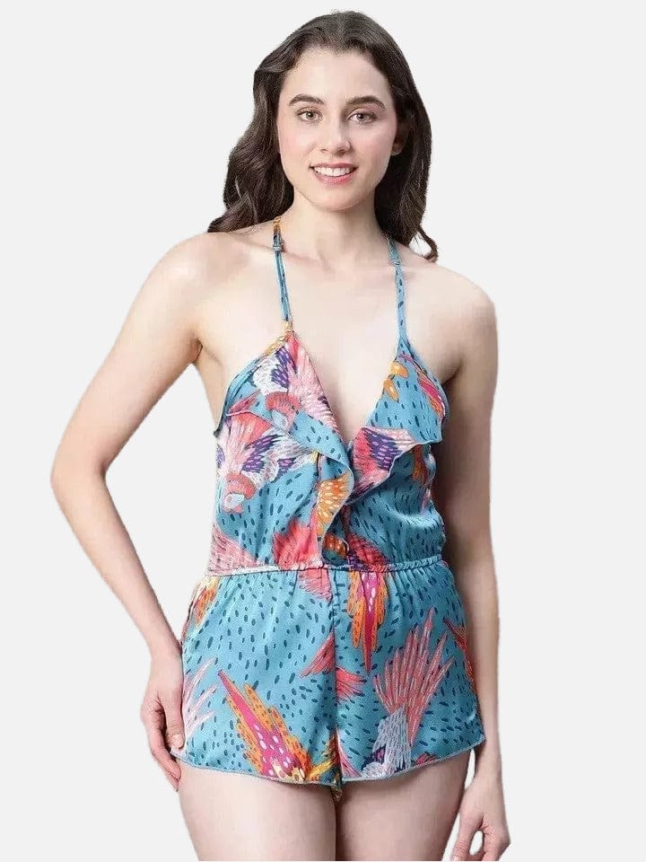 A woman wearing a colorful floral print dress with a plunging neckline and shorts.