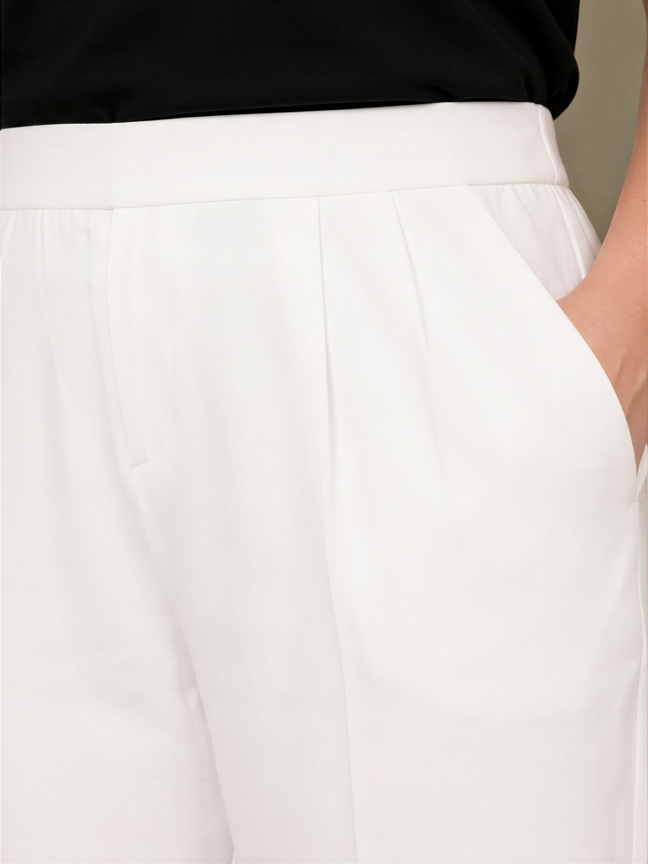A close-up view of a person wearing white pants.