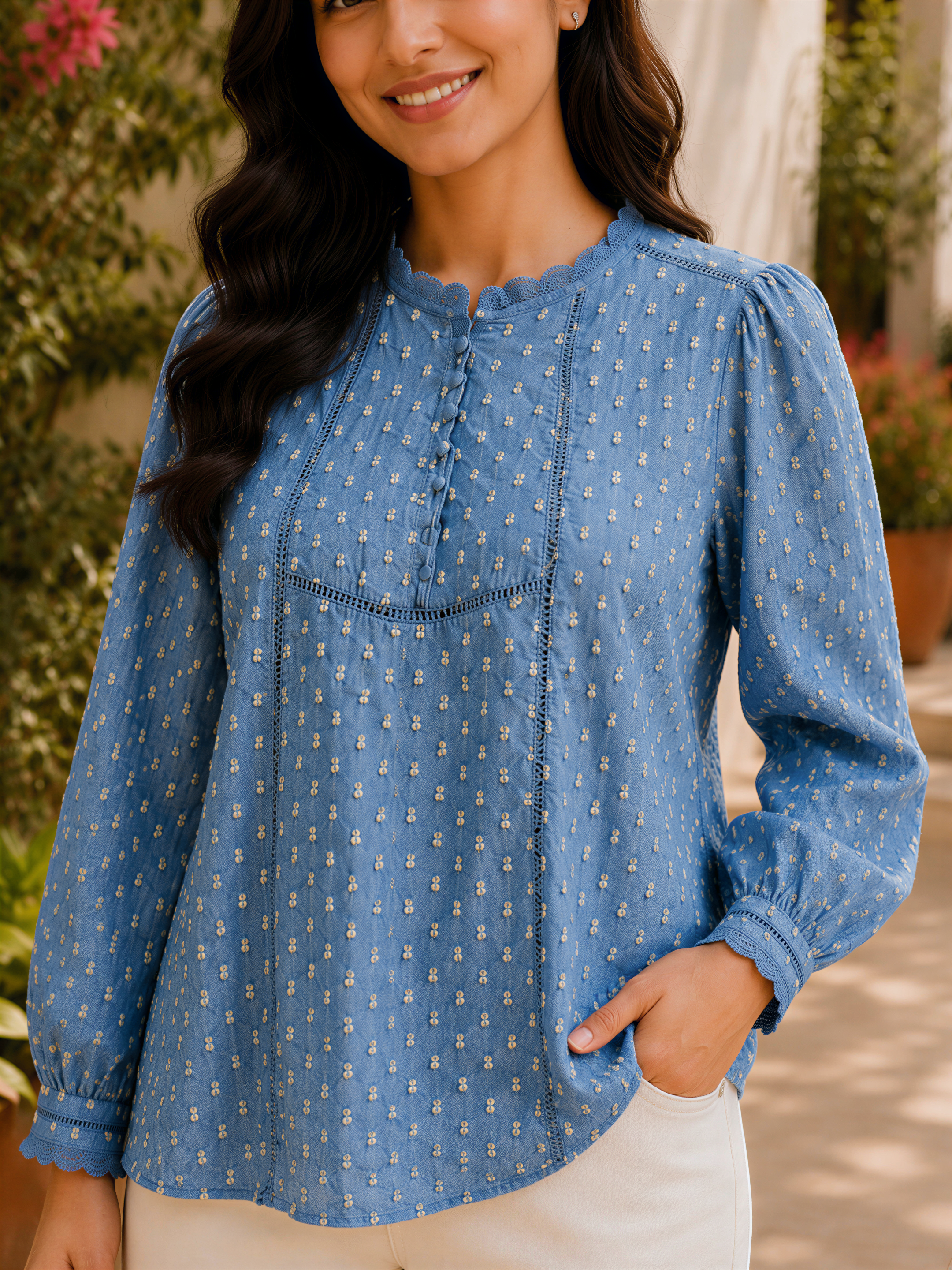A woman wearing a blue blouse with white polka dots and white pants, smiling at the camera.