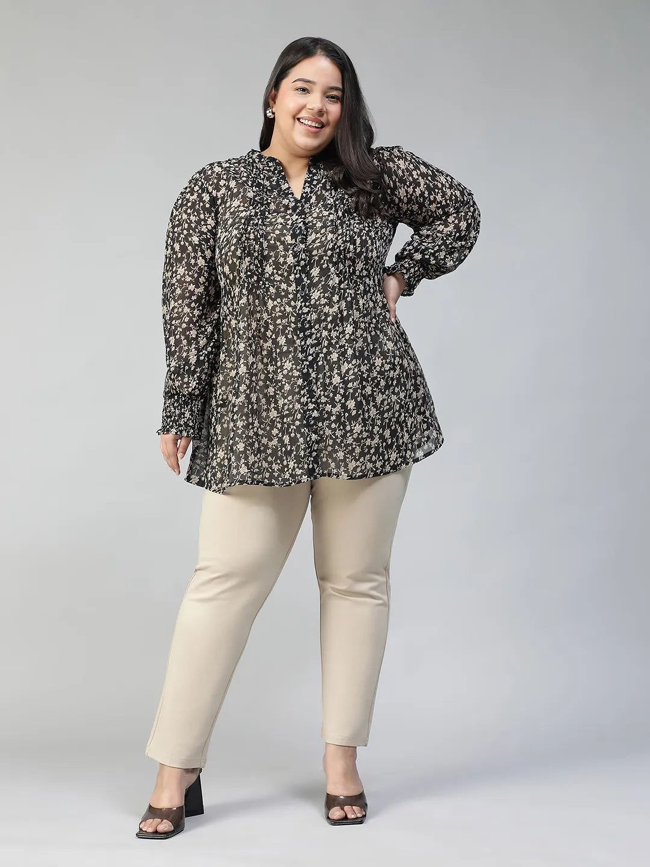 Woman wearing a black floral blouse against a gray background