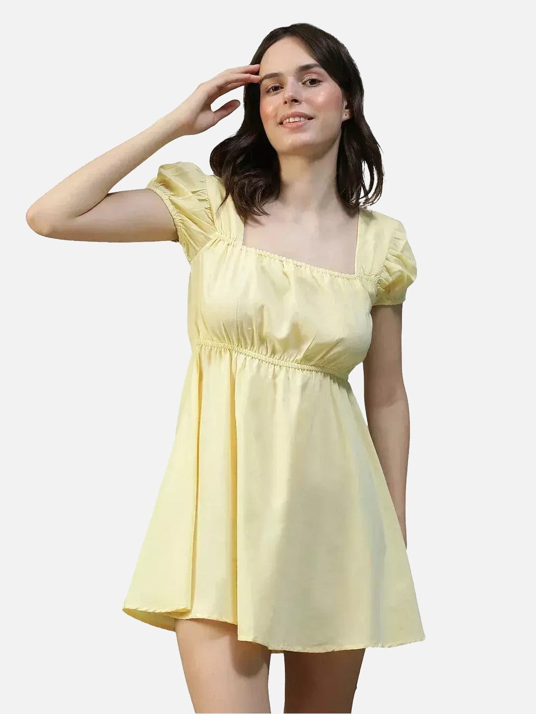 A woman wearing a yellow dress with a ruffled collar and short sleeves, smiling and posing with her hand on her head.