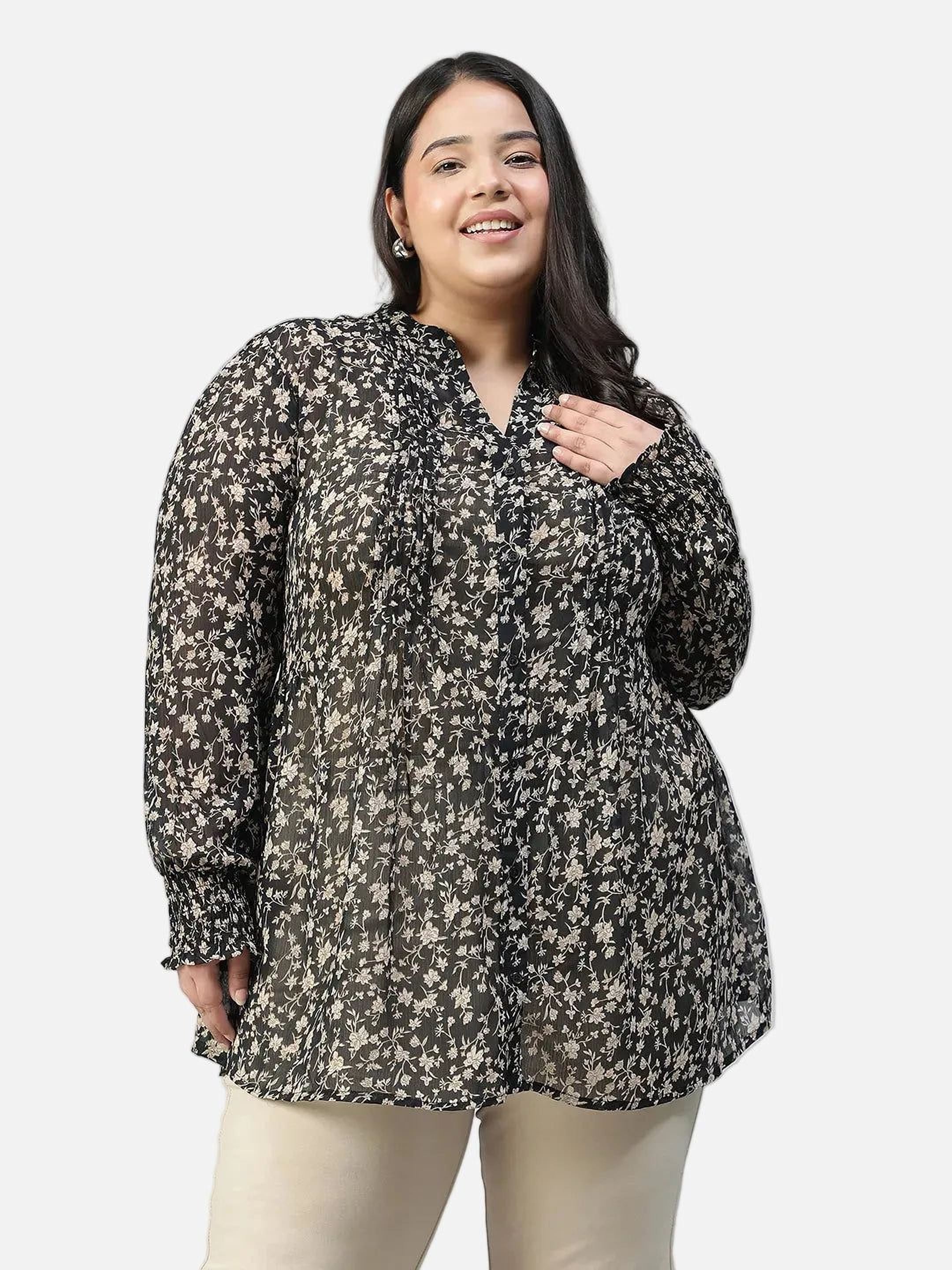 Woman wearing a black floral blouse against a gray background