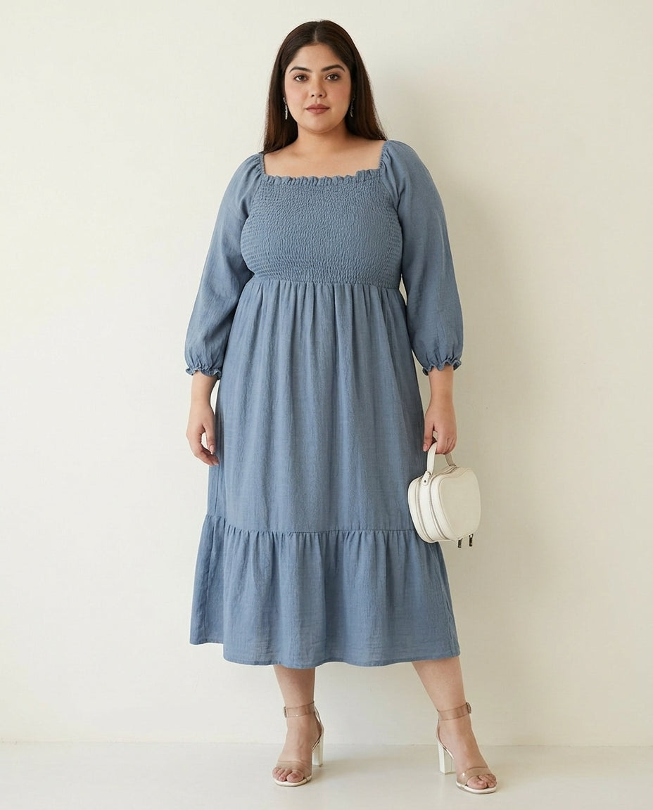 Plus size woman wearing light blue smocked midi dress with puff sleeves and holding white purse
