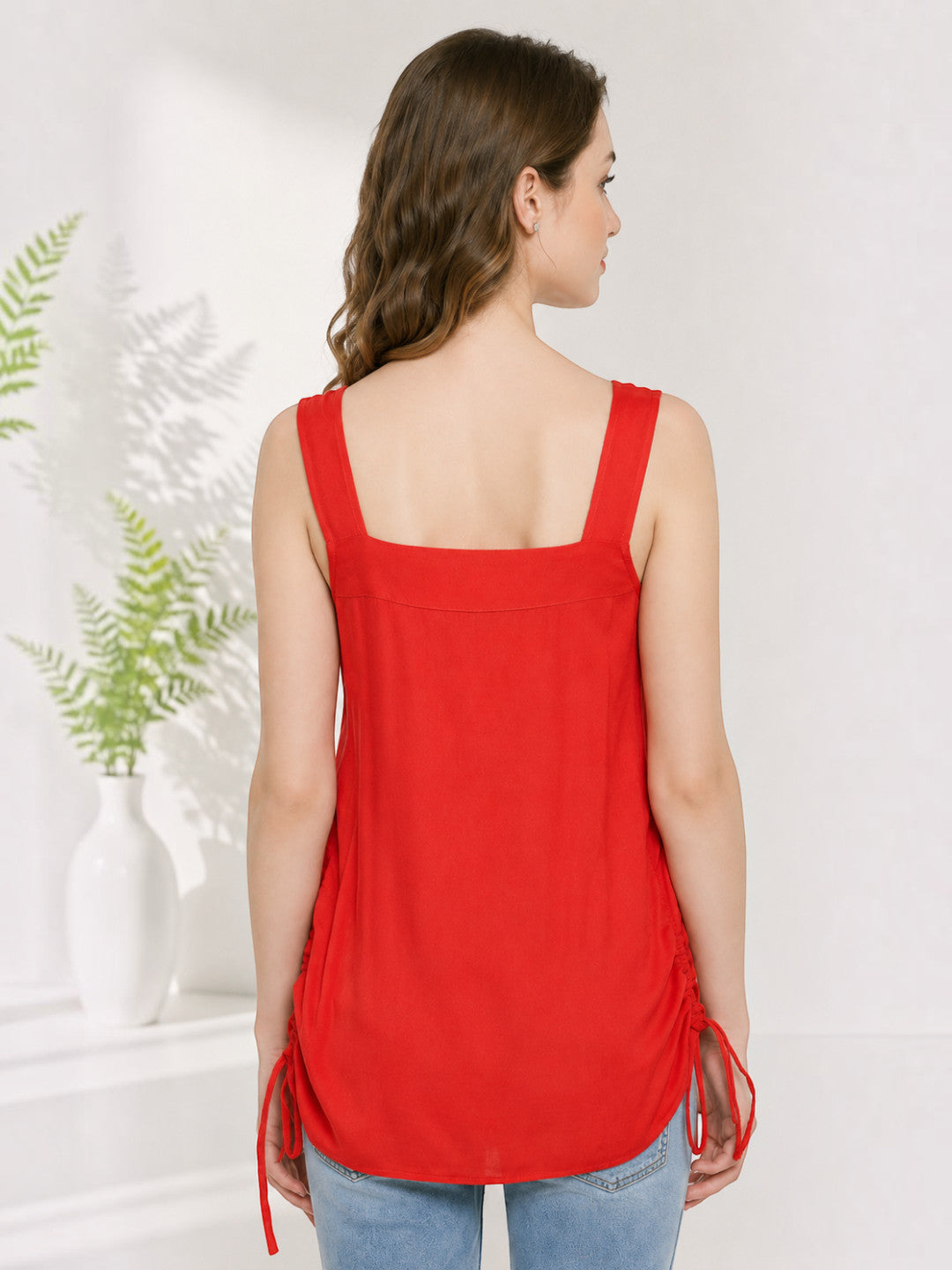 Red sleeveless top with side ties, back view, paired with jeans for women's fashion