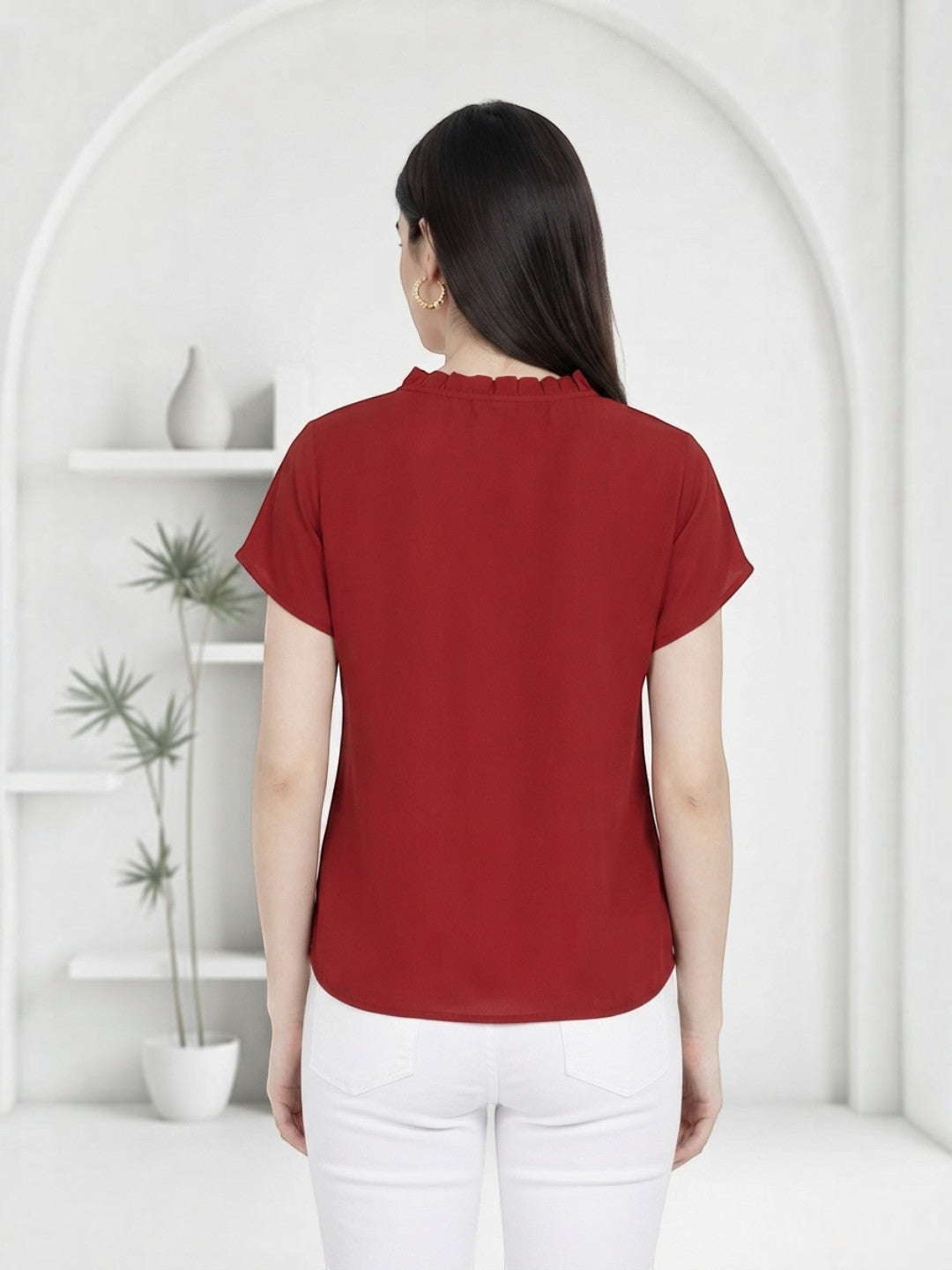 Red women's blouse with ruffled neckline, paired with white jeans, back view