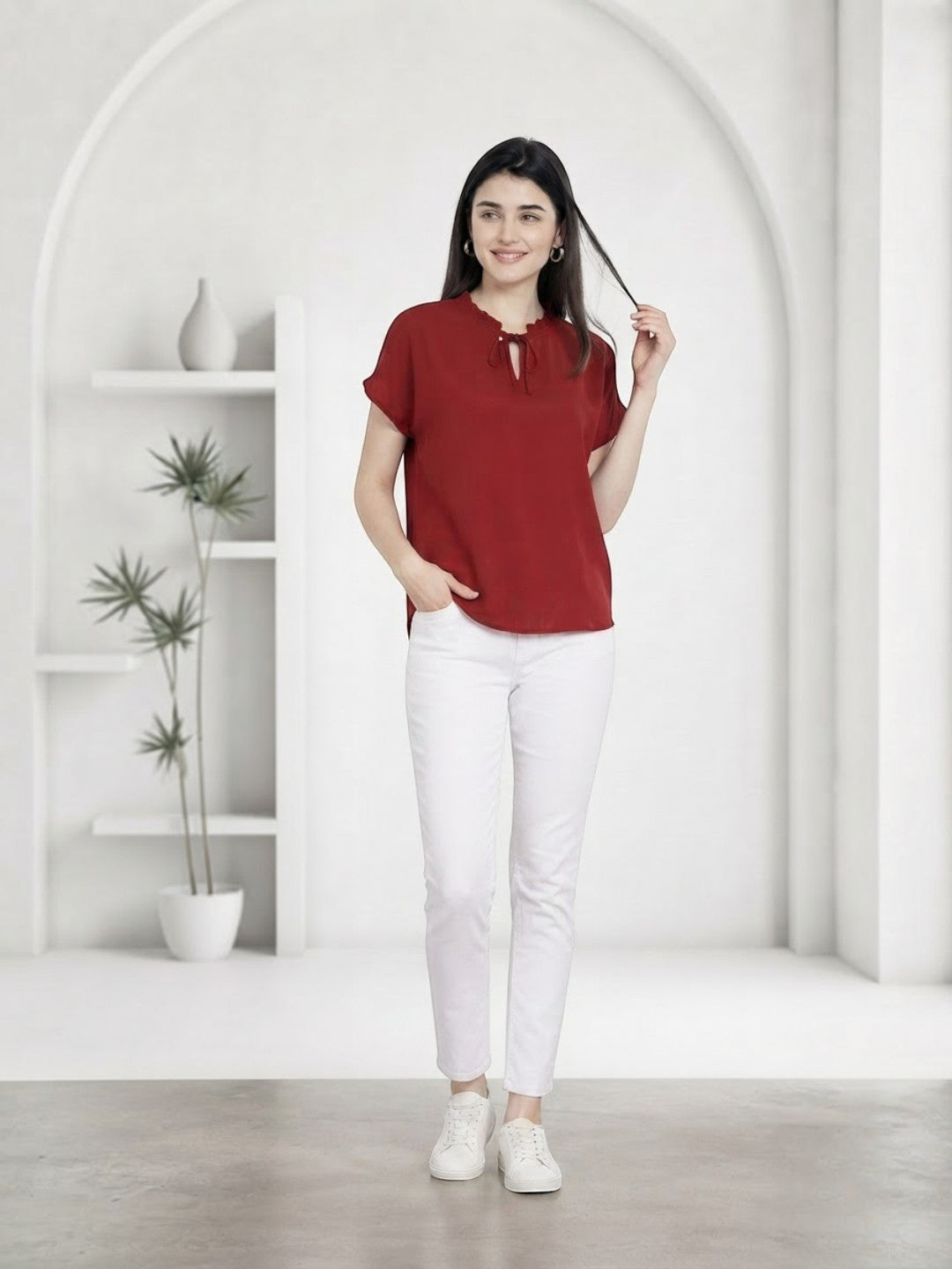 Woman in red tie-neck blouse and white jeans, stylish plus size fashion outfit