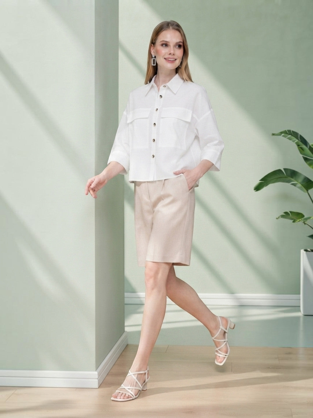 Woman in white button-up shirt and beige shorts, stylish plus size fashion outfit