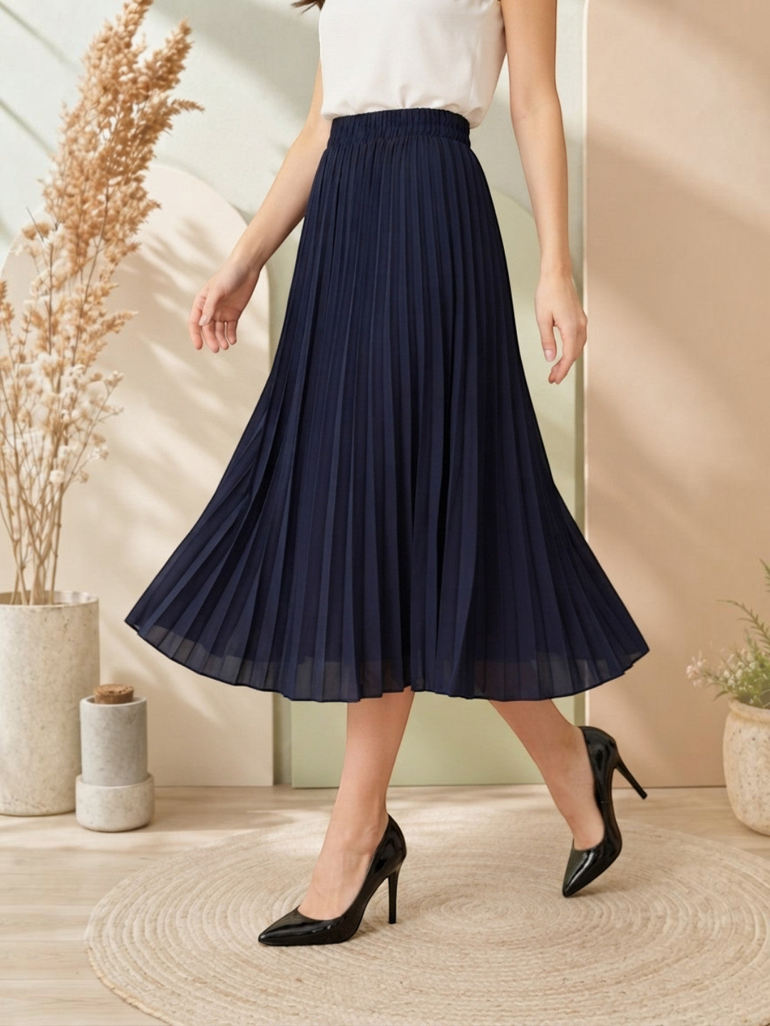 Navy blue pleated midi skirt with elastic waist, paired with white top and black heels for women's fashion
