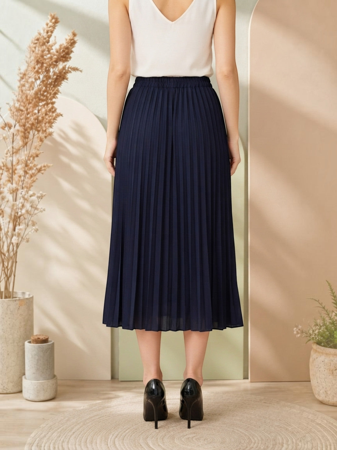 Navy pleated midi skirt for women, paired with white top and black heels, stylish office wear