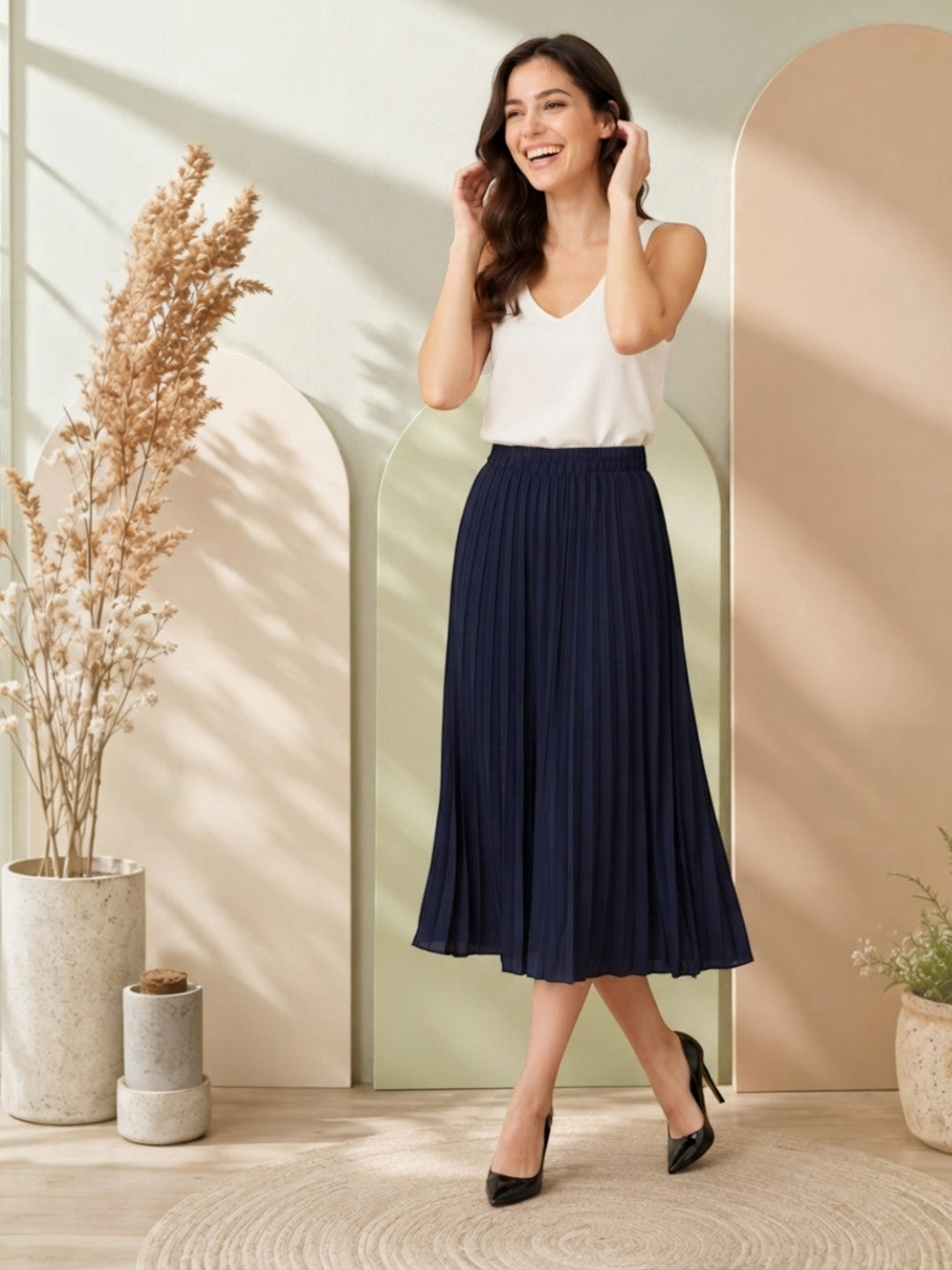 Woman in navy pleated midi skirt with white top, stylish plus size fashion outfit