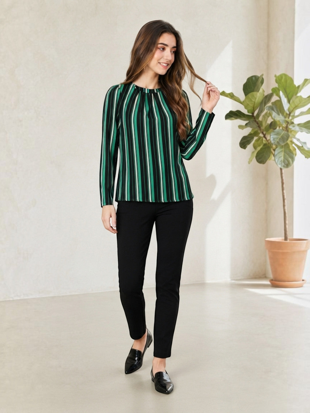 Woman in green and black striped long sleeve top with black pants, stylish plus size fashion outfit