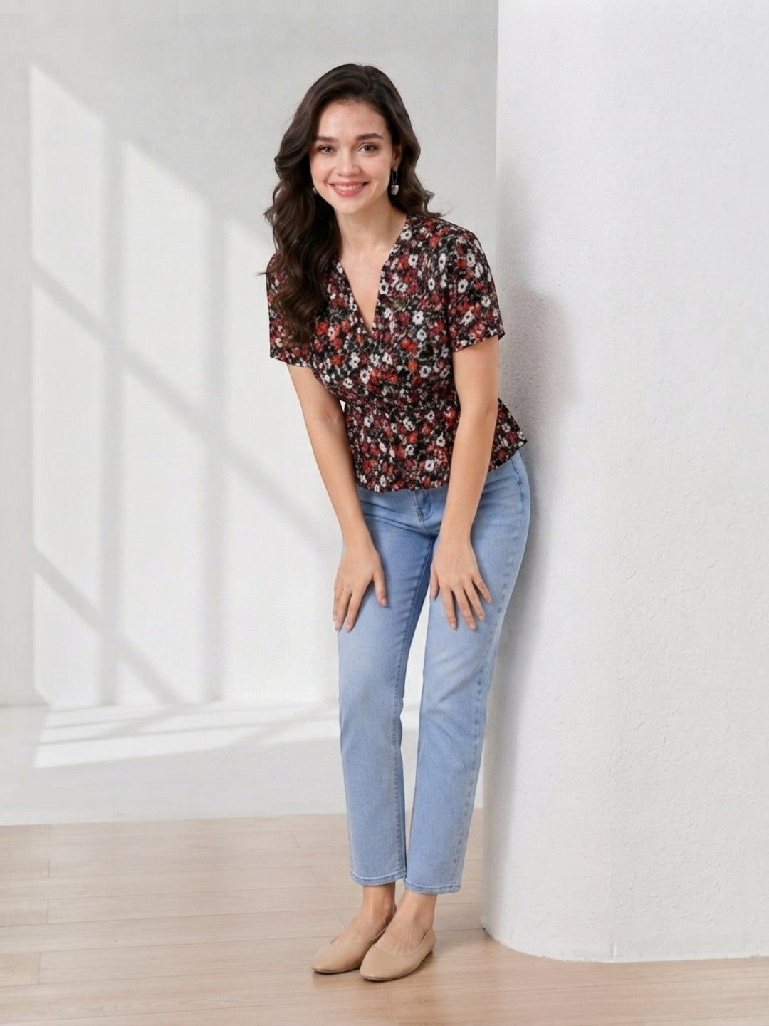 Woman in floral V-neck top and light blue jeans, stylish plus size fashion outfit