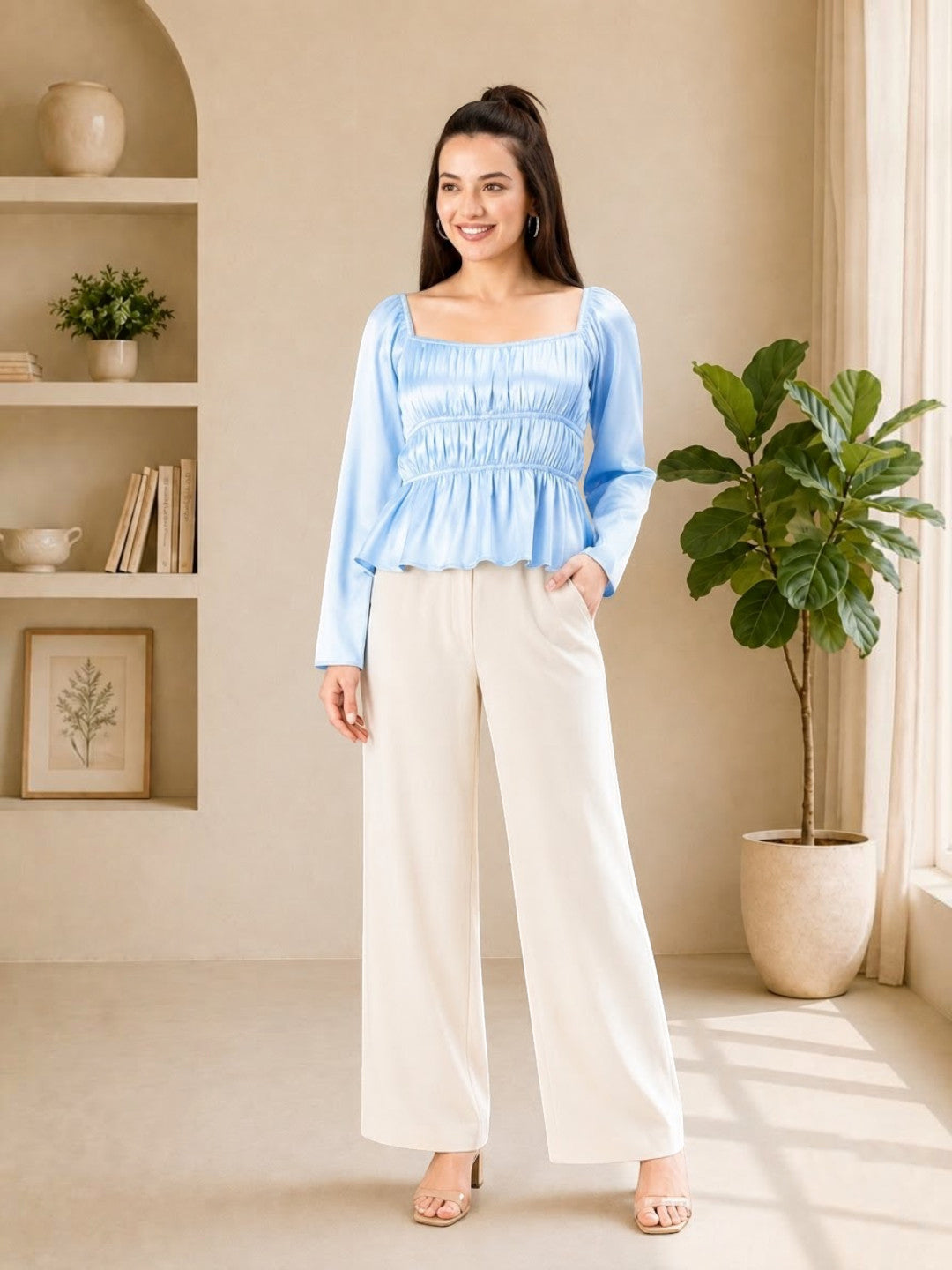 Woman in light blue smocked top and cream wide-leg pants, stylish plus size outfit