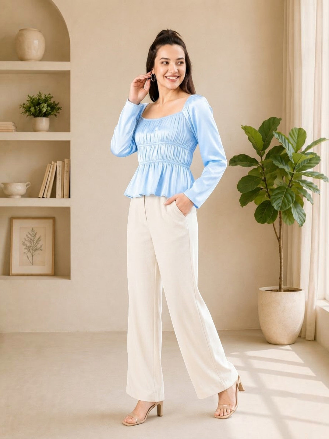 Woman in light blue peplum top and cream wide-leg pants, stylish plus size outfit