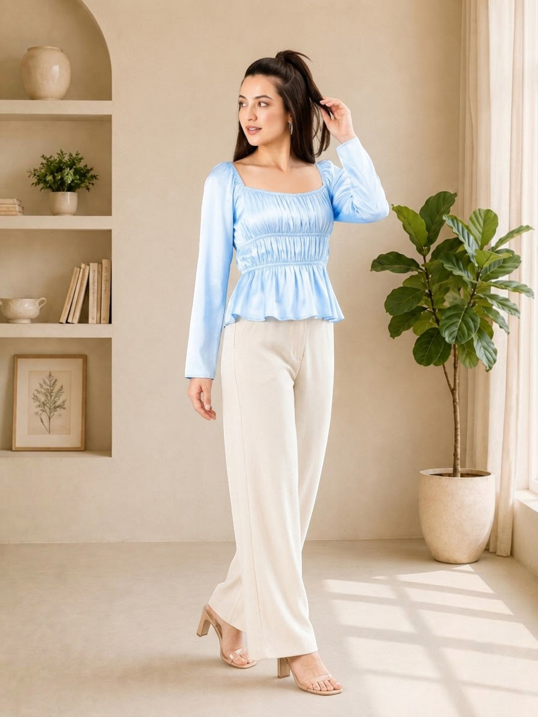 Woman in light blue long sleeve peplum top with cream wide-leg pants, stylish plus size outfit