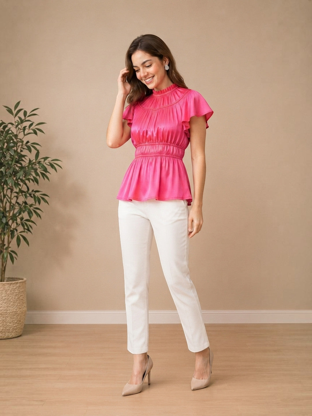 Woman in pink peplum top with ruffled sleeves, white pants, and heels for trendy women's fashion