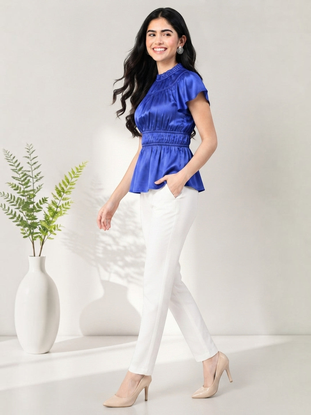 Woman in royal blue peplum top with white pants, stylish plus size fashion outfit