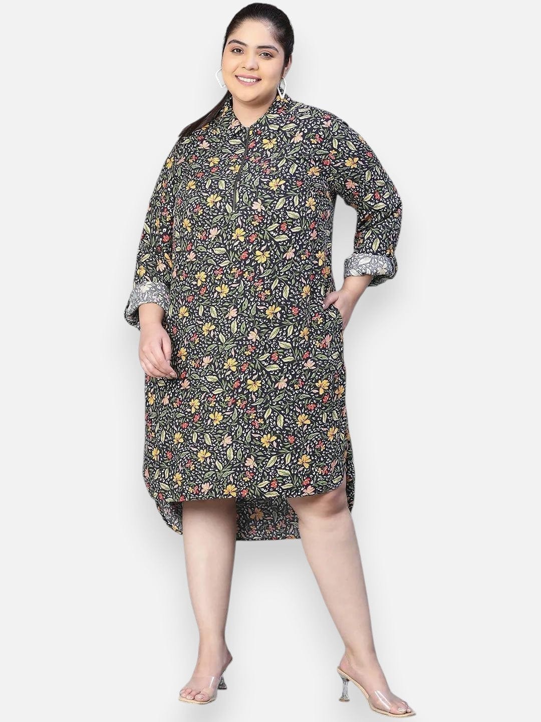 A woman wearing a black and white floral print dress with a high collar and long sleeves, smiling at the camera.