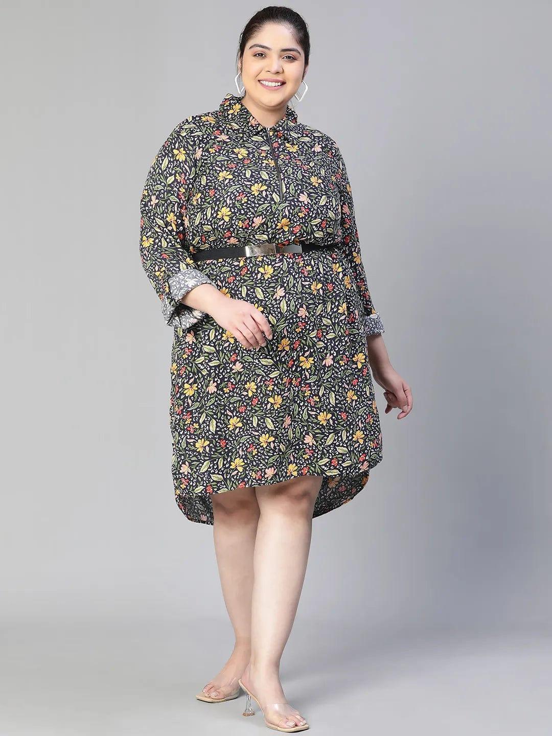 A woman wearing a black and white floral print dress with a high collar and long sleeves, smiling at the camera.