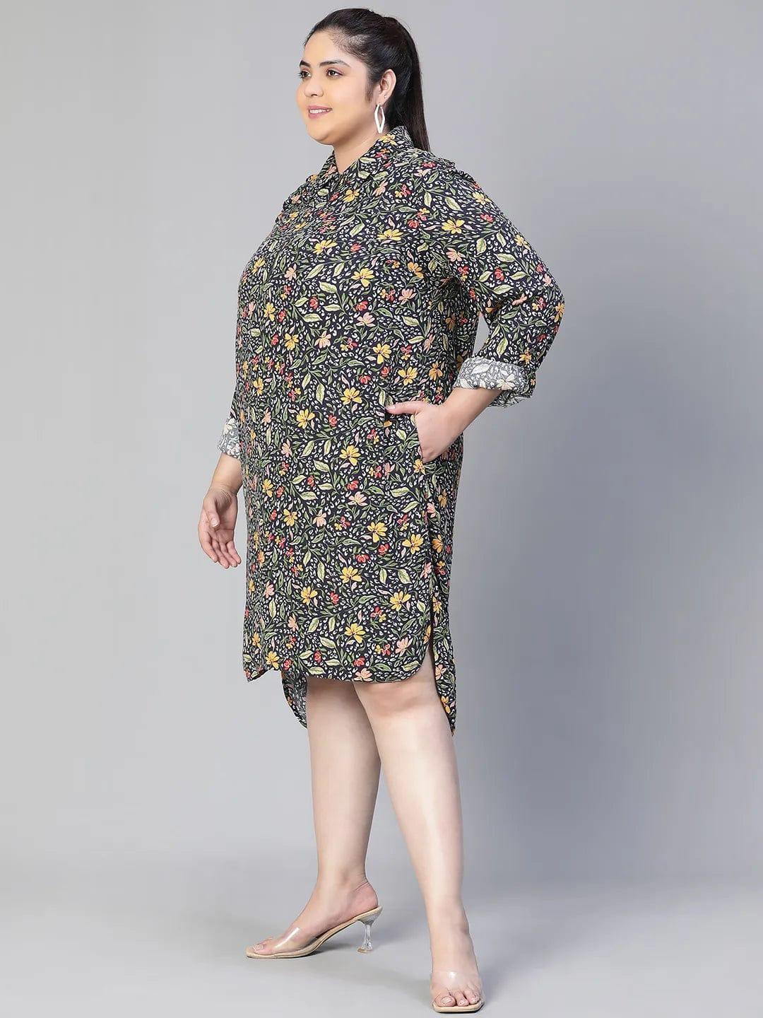 A woman wearing a black and white floral print dress with a high collar and long sleeves, smiling at the camera.
