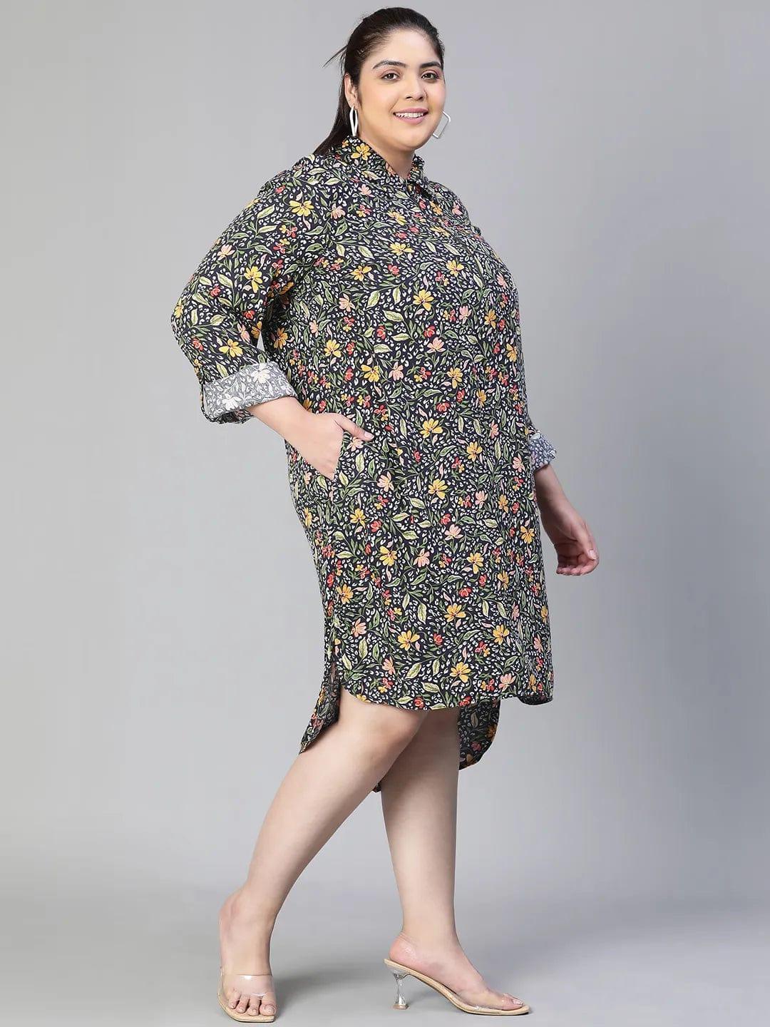 A woman wearing a black and white floral print dress with a high collar and long sleeves, smiling at the camera.