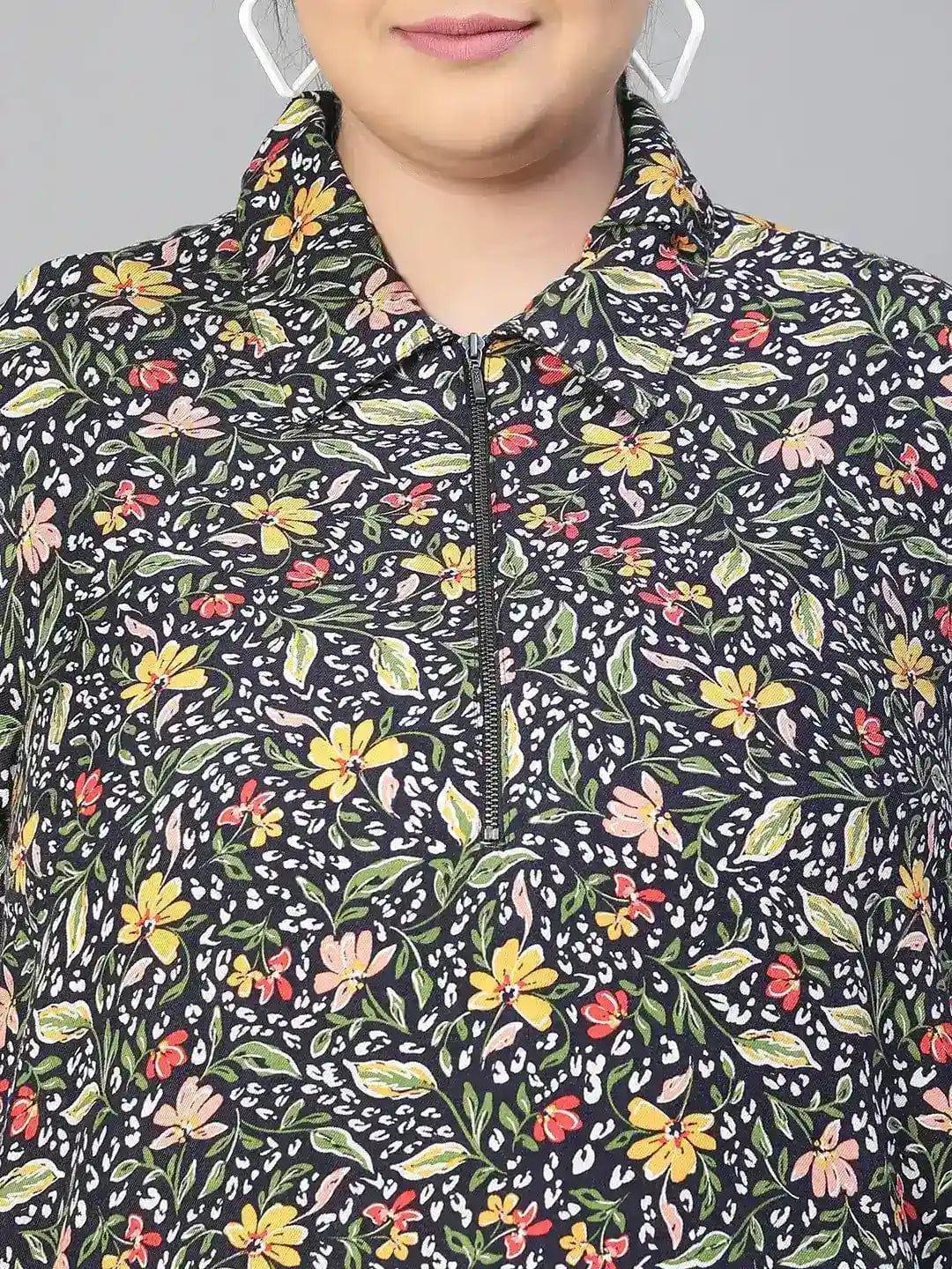 A woman wearing a black and white floral print dress with a high collar and long sleeves, smiling at the camera.