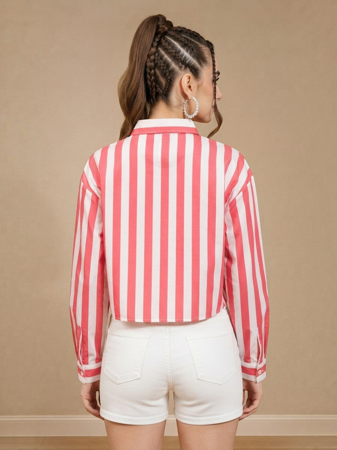 Woman wearing pink and white striped cropped shirt with white shorts, back view