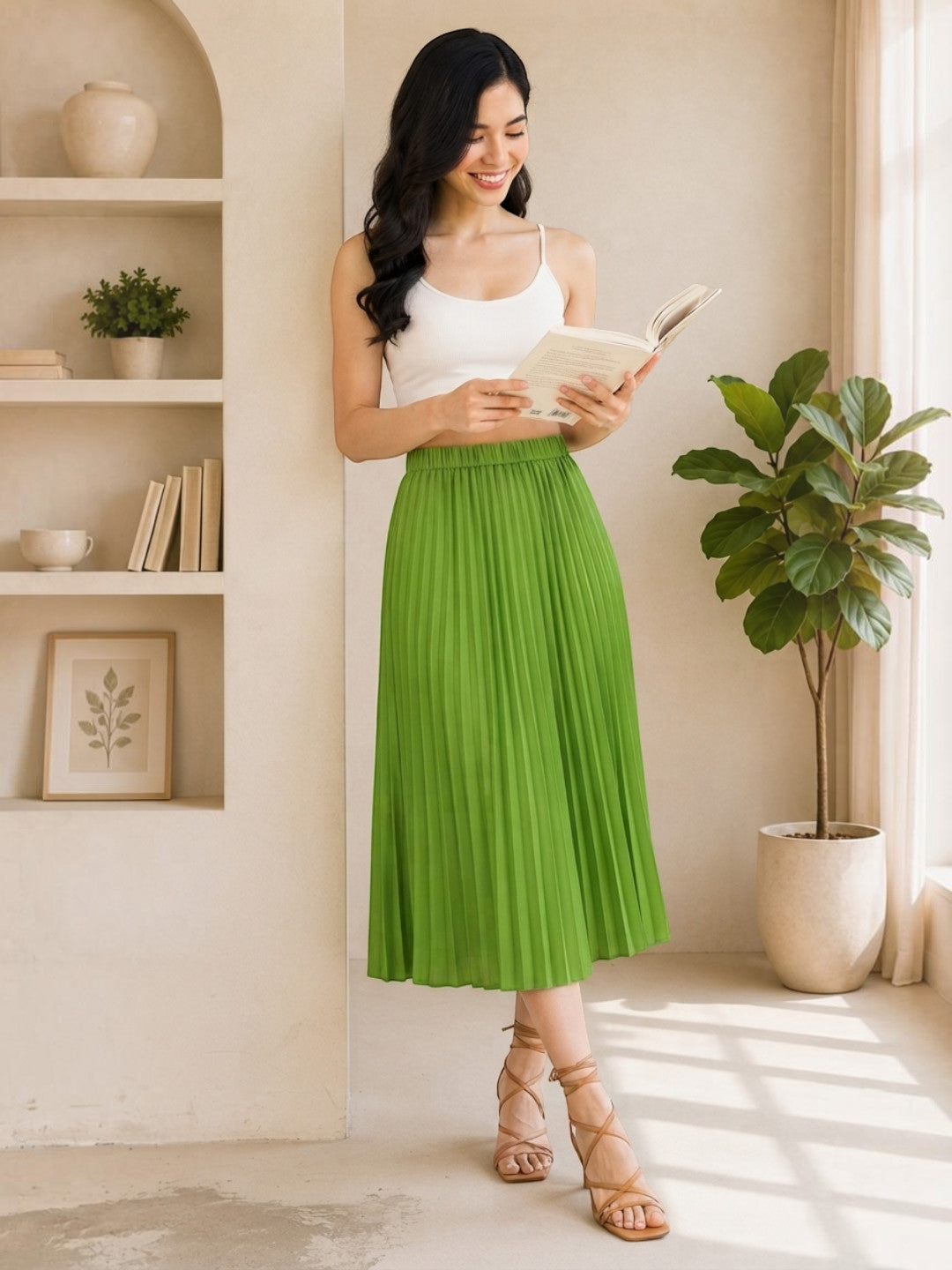 Woman in green pleated midi skirt reading book, stylish plus size fashion outfit
