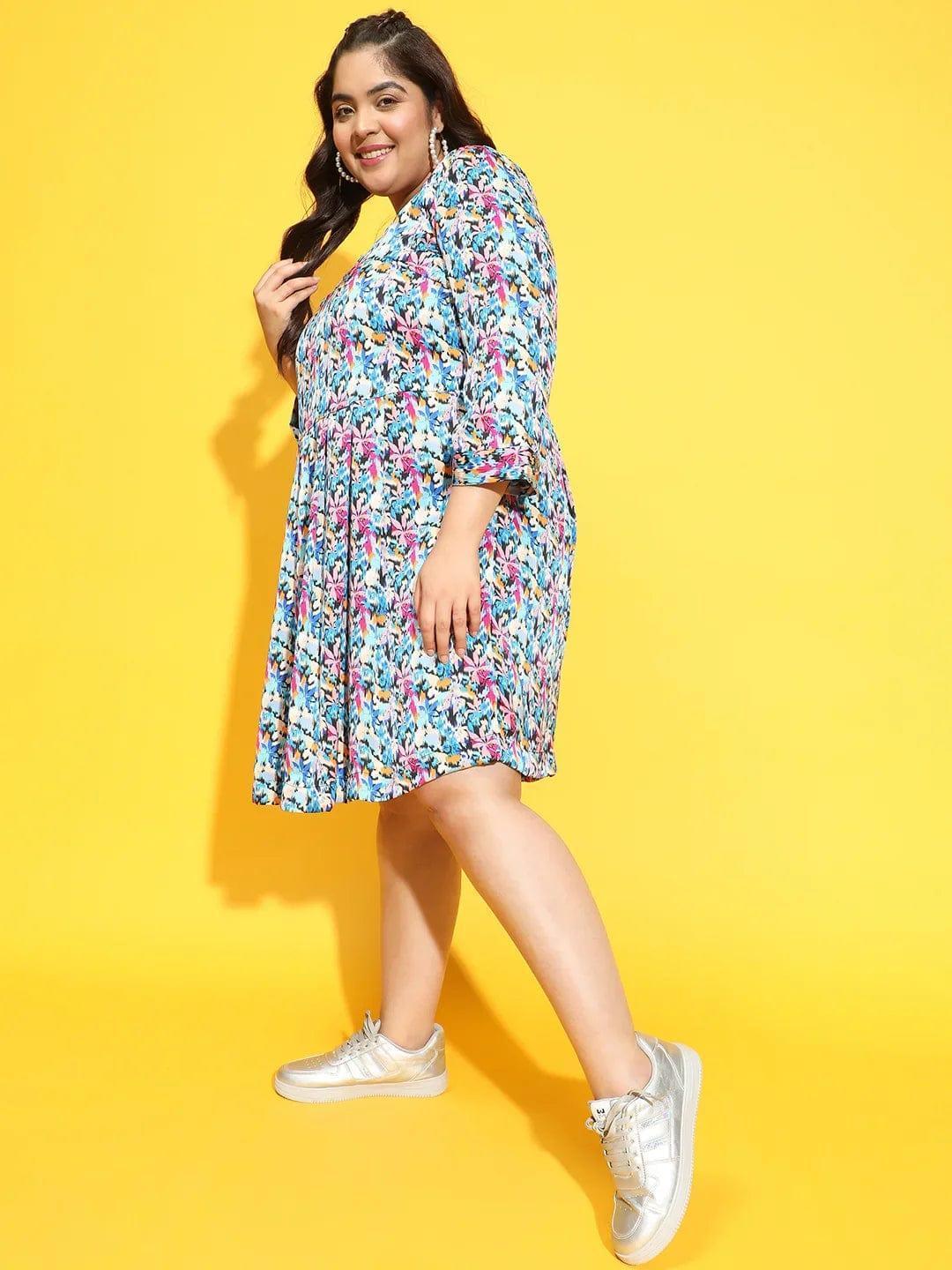 A woman wearing a colorful floral print dress and gold sneakers is smiling and posing for the camera.