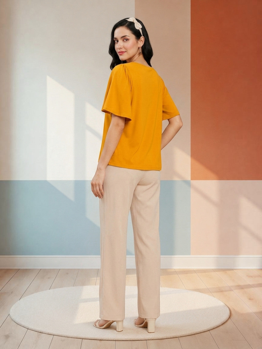 Woman in mustard yellow top and beige wide-leg pants, stylish plus size outfit for casual wear