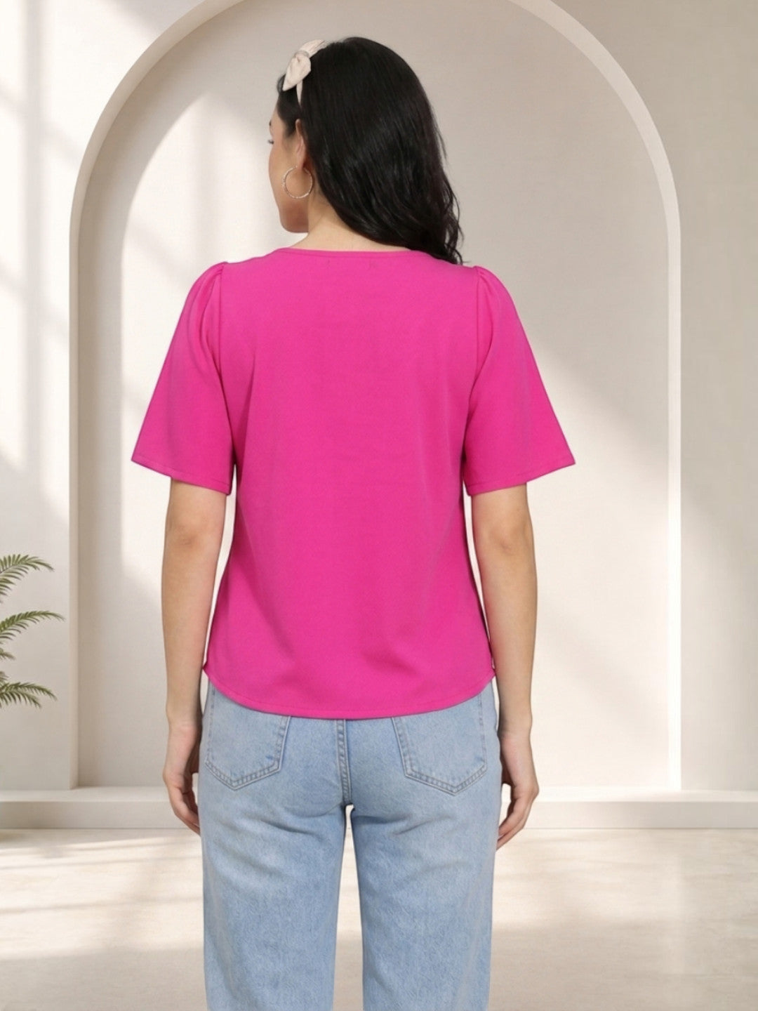 Bright pink women's top with puff sleeves, paired with light blue jeans, stylish casual wear