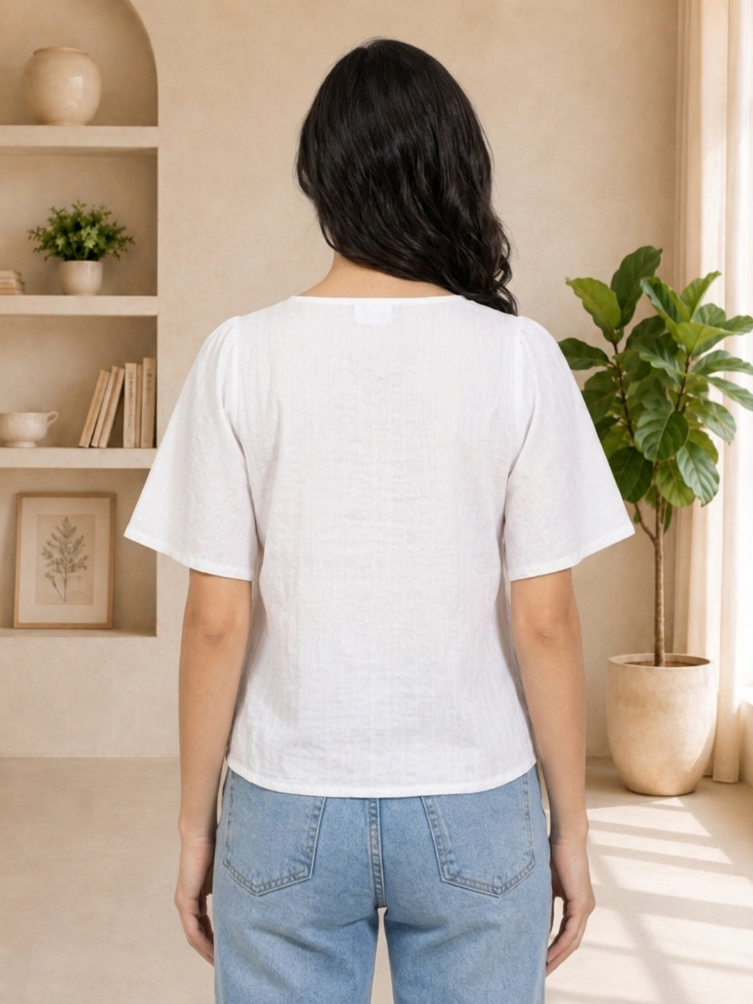 White textured blouse with puff sleeves, back view, paired with light blue jeans, casual women's fashion