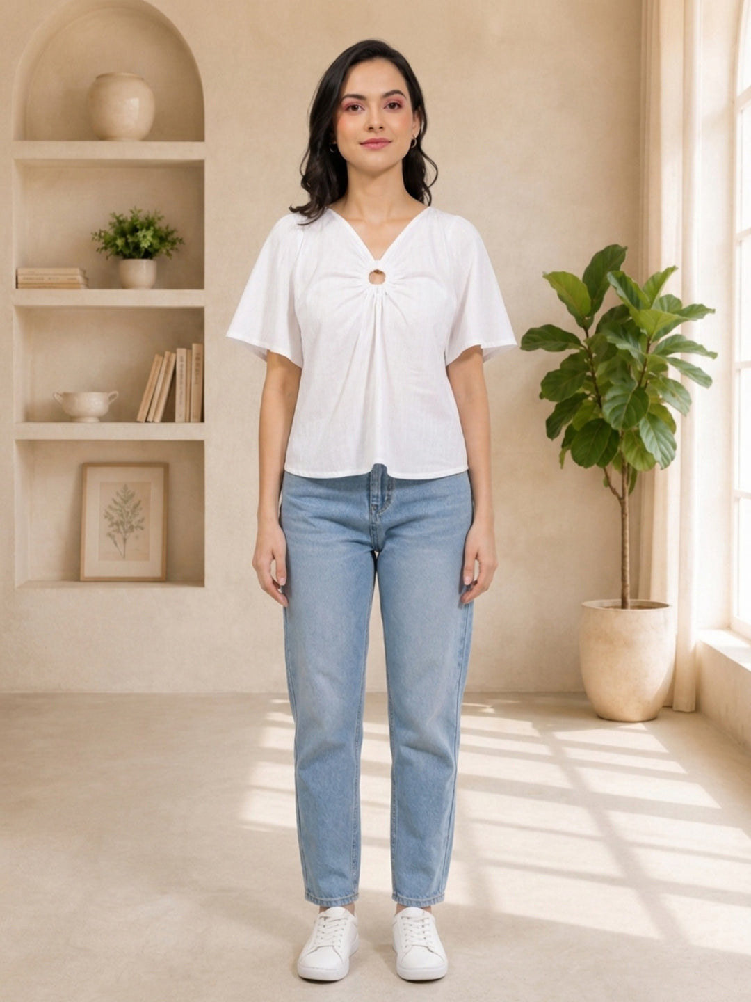 White V-neck blouse with front knot detail, paired with light blue jeans and white sneakers for casual women's fashion