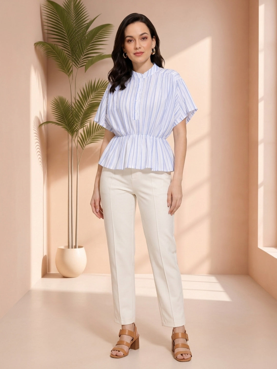 Woman in blue striped peplum top and white pants, stylish plus size outfit for women