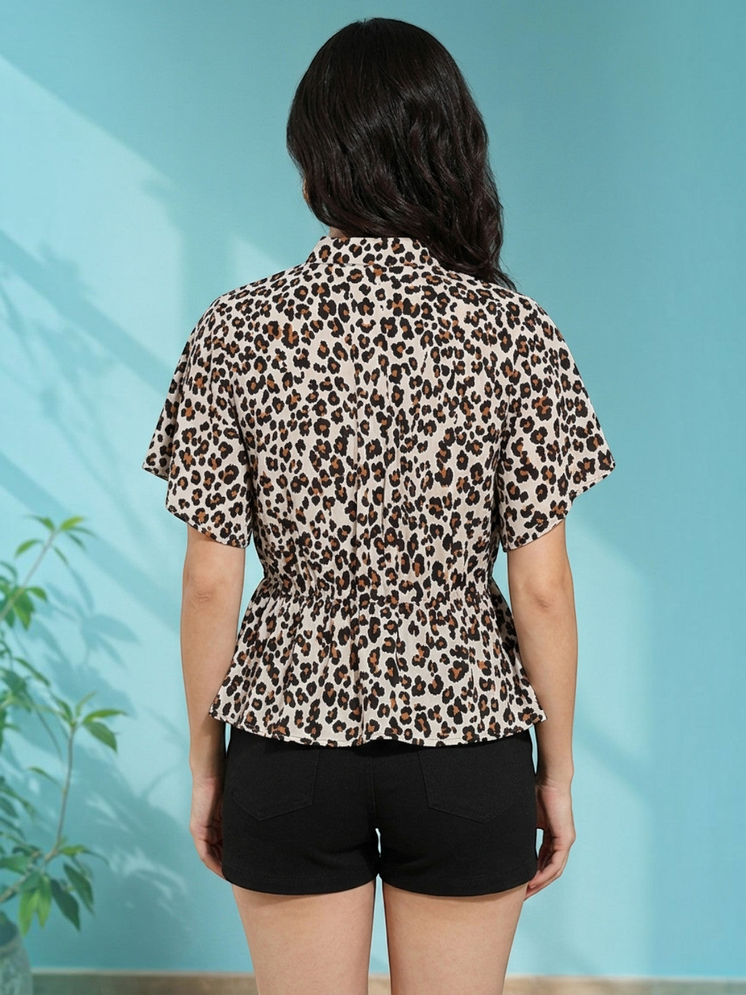 Leopard print peplum blouse with short sleeves, back view, paired with black shorts for women's fashion