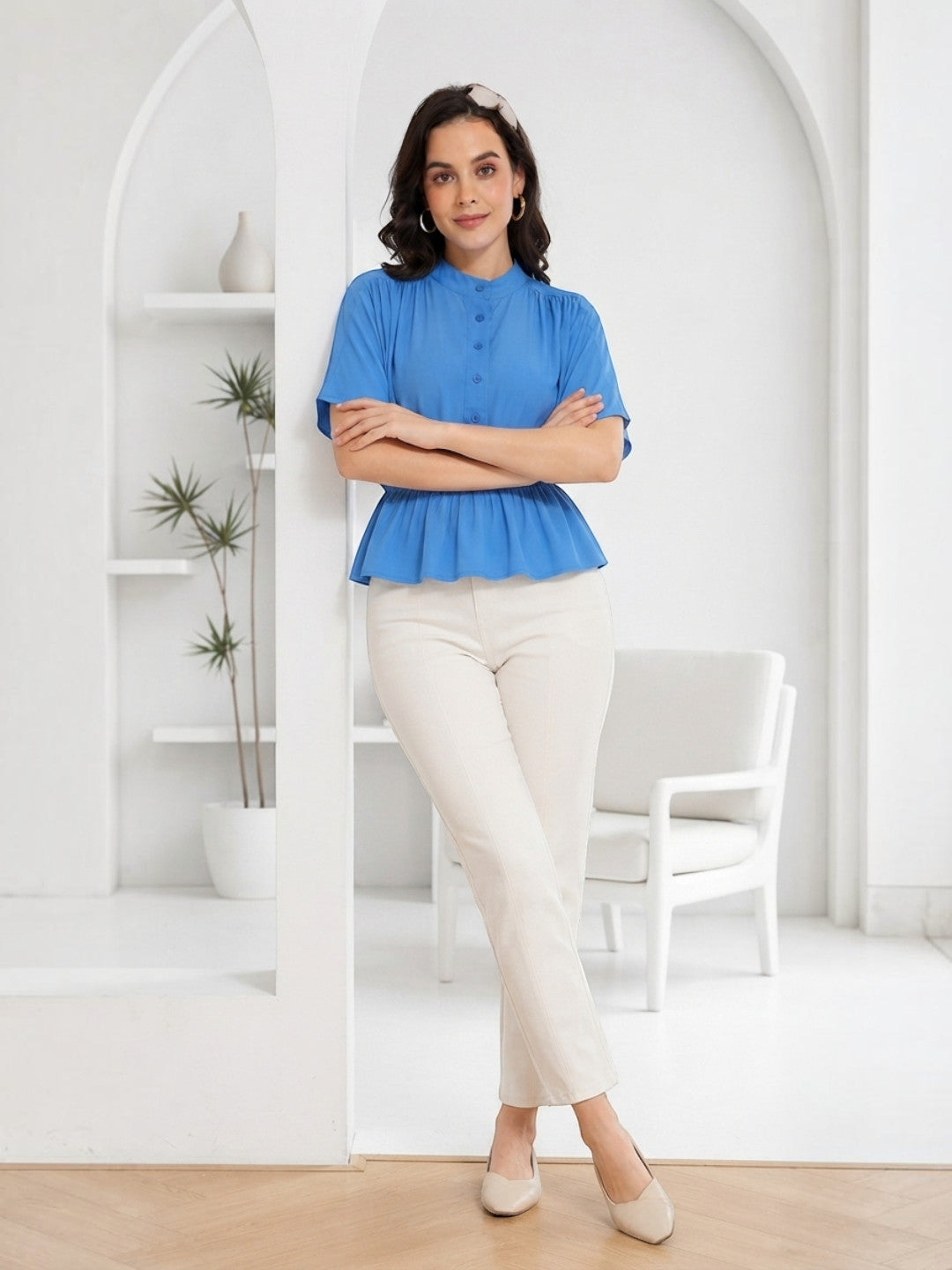 Woman in blue peplum top and cream pants, stylish plus size fashion outfit