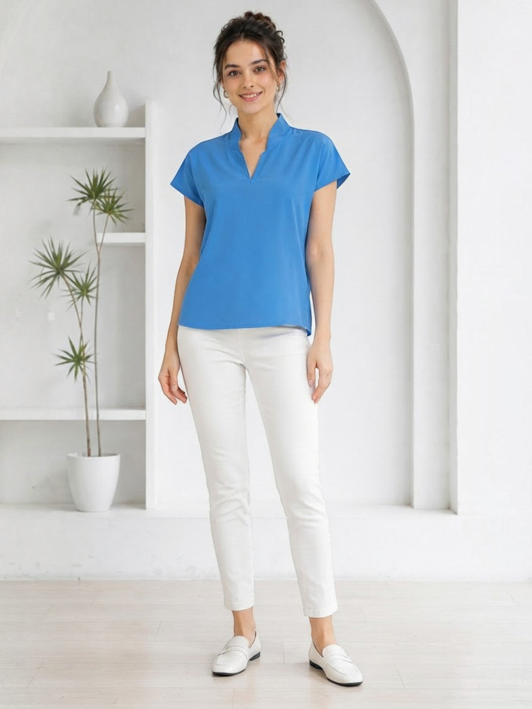 Woman in blue V-neck top and white pants, stylish plus size fashion outfit