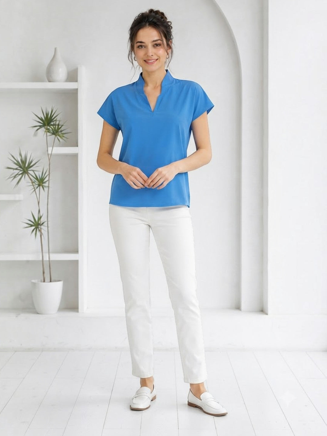 Woman in blue V-neck short sleeve top and white pants, stylish plus size fashion outfit