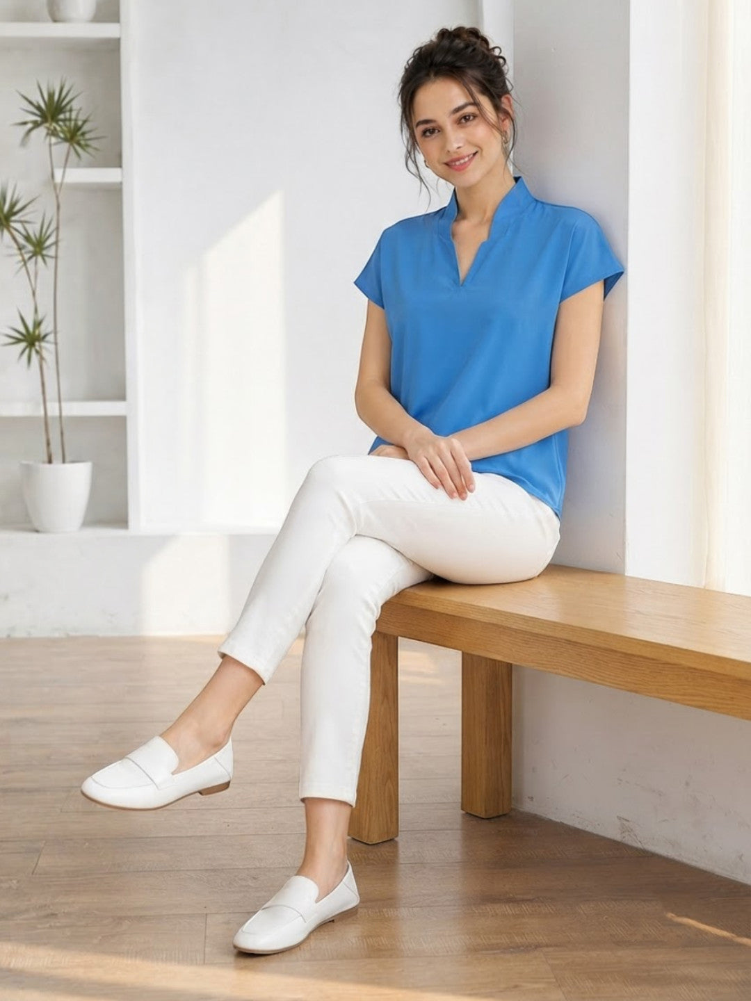 Woman in blue V-neck top and white pants, stylish plus size fashion outfit
