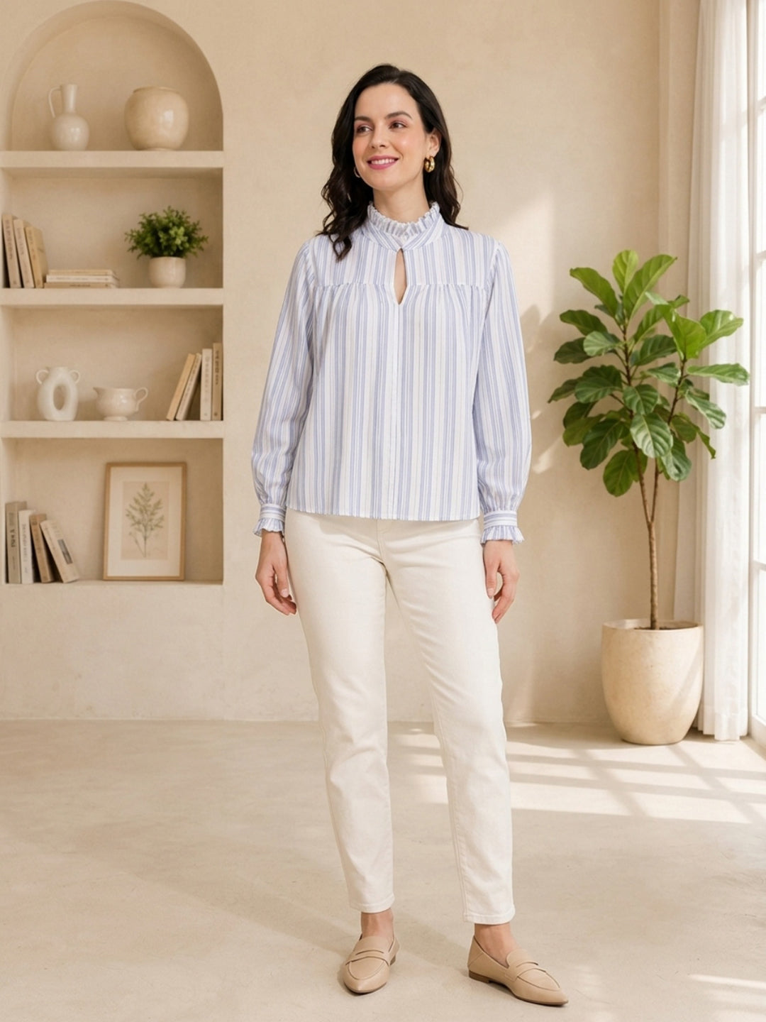 Woman in blue and white striped blouse with ruffled collar, paired with cream pants and loafers, styled for casual fashion.