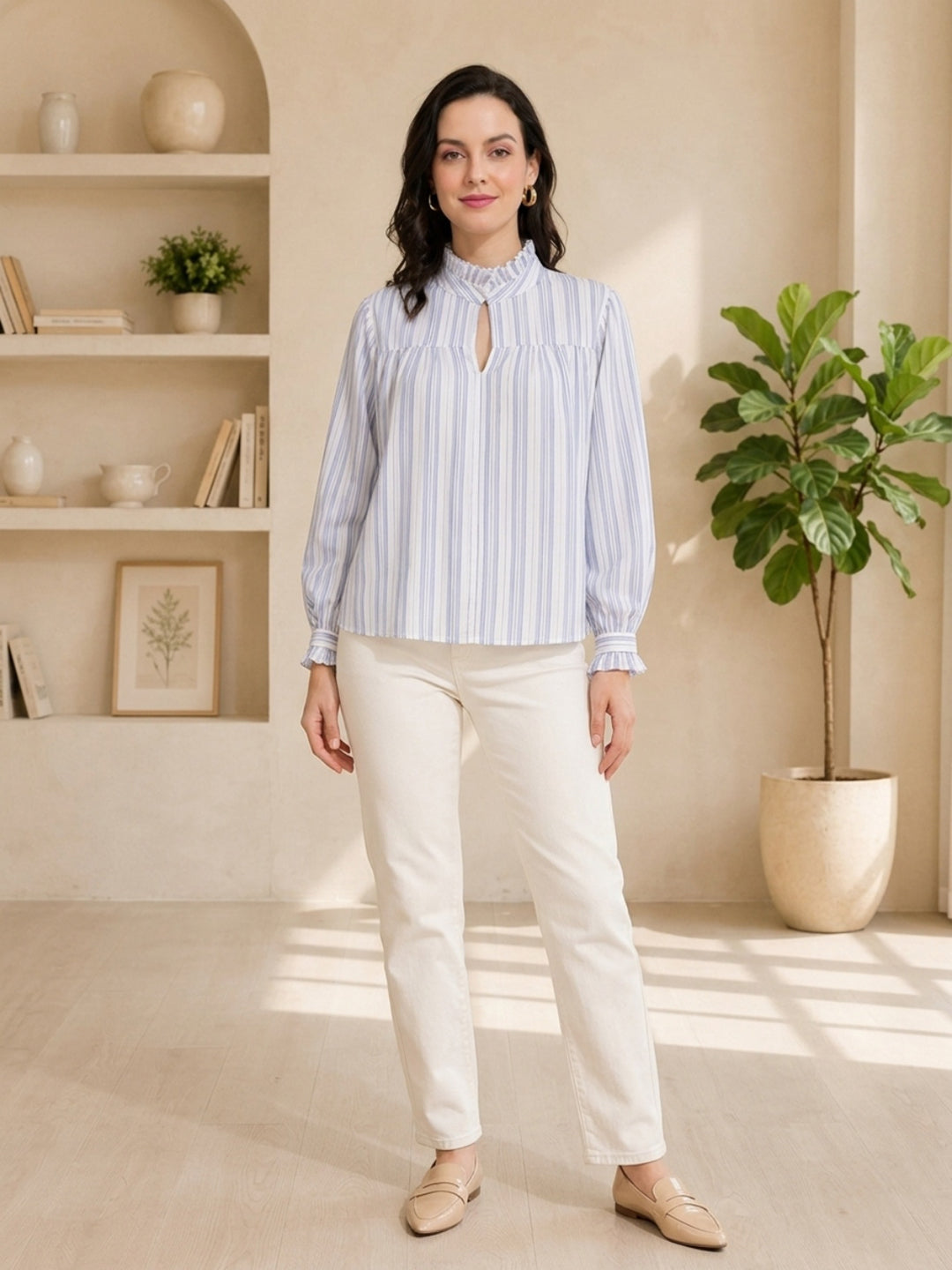 Woman in blue and white striped blouse with ruffled collar, paired with cream pants and loafers, styled for casual wear.
