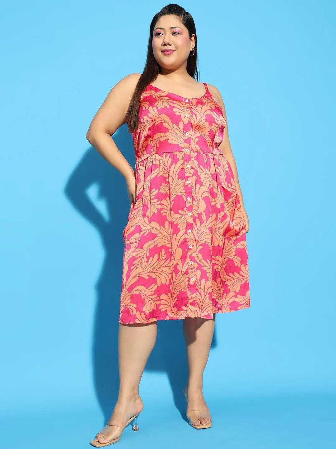 A woman wearing a pink floral print dress and holding a white purse stands against a white background.